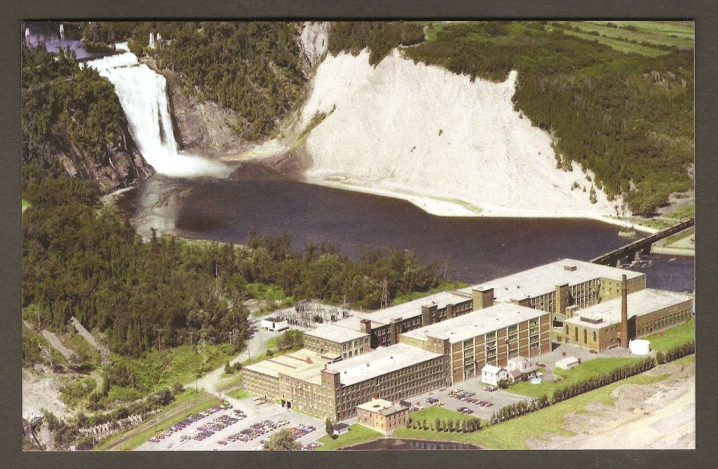 Carte postale de la belle collection des Archives du Photographe, publiée en 2010, et illustrée d'une photo aérienne de Charles-Henri Leclerc, prise le 2 août 1976. On y voit les bâtiments de la Dominion Textile, ainsi que la chute Montmorency, en arrière-plan.
