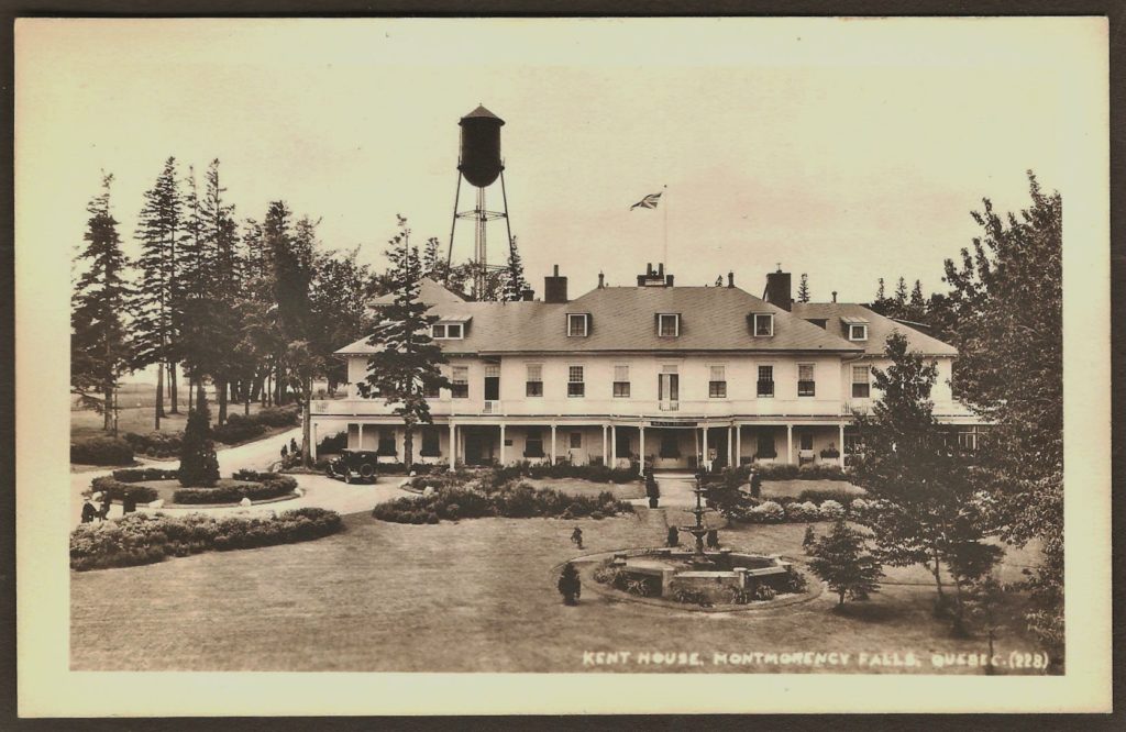 Une carte postale « photo réelle » montrant la façade du Kent House, vers 1925. Des automobiles d'époque sont stationnées devant l'hôtel et on remarque la présence de personnes sur le balcon donnant sur la salle de bal, à droite.